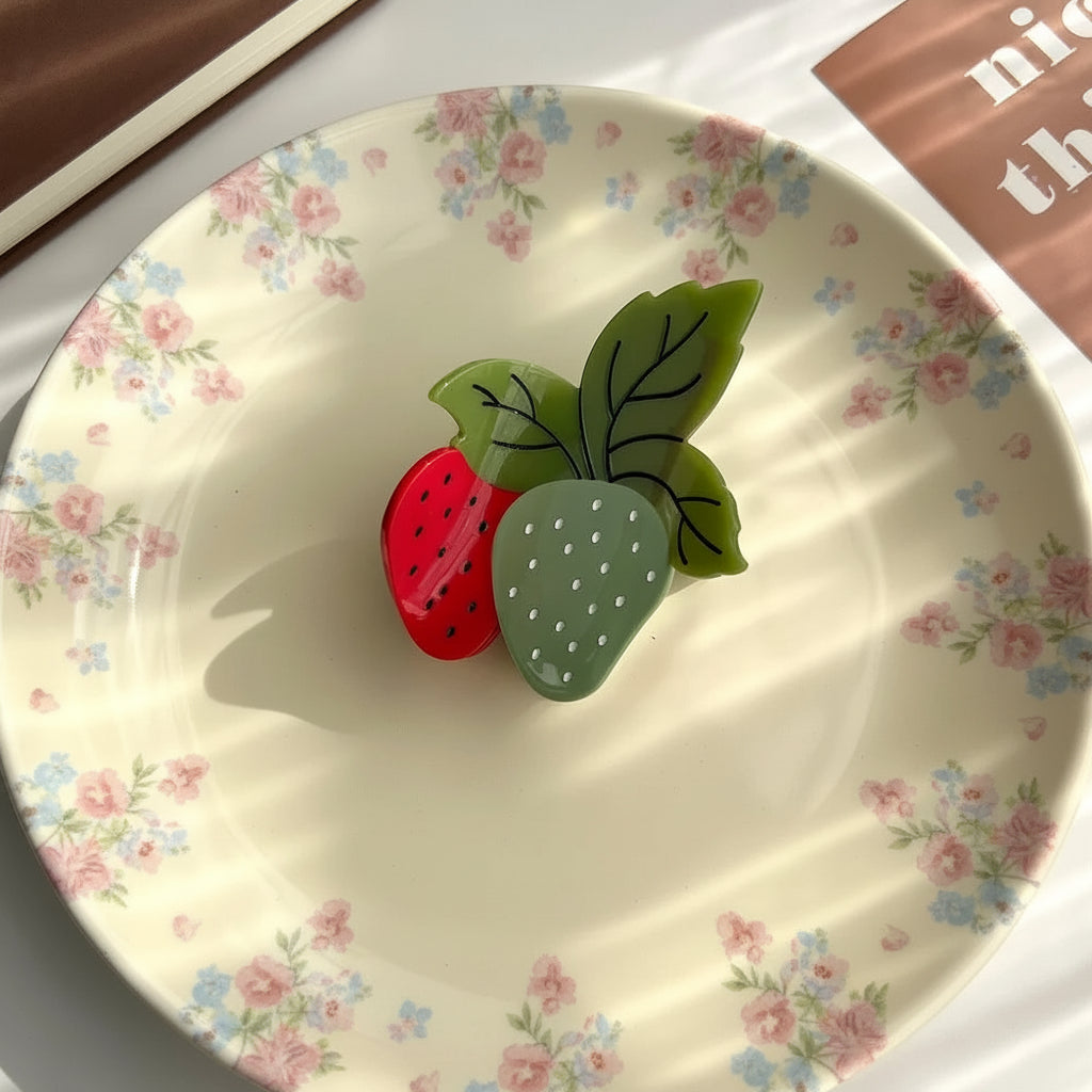 green and red strawberry hair claw clip on a cream ditsy floral plate